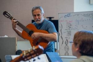 吉他指导员在音乐课上教和弦.